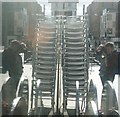 View of the reflection of a stack of chairs from the Hot Italian Cafe in the Blue Fin Building