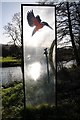 Backlit artwork beside the River Frome