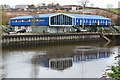 Bright blue industrial units beside the River Dart