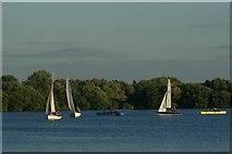 TQ4590 : View of three sailing boats and two canoes on the lake in Fairlop Waters by Robert Lamb