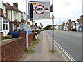 Looking under battered sign towards queue at bus stop on Old Shoreham Road