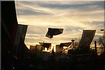TQ2481 : View of flags against the setting sun from the Portobello Road Winter Festival #4 by Robert Lamb