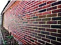 Brick wall by footpath