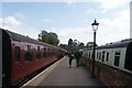 View of a diesel train at the platform and a slam door carriage in the siding at Ongar station