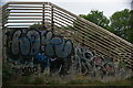 View of graffiti on the side of the footbridge in Roding Valley Park
