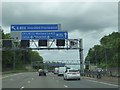 TQ0495 : Speed and sign gantry and footbridge near M25 junction 18 by David Smith