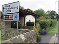 Bus shelter and a stone in the hedge in Northop