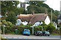 SW7624 : Lovely thatched house with the tower of the parish church of St Manaccus showing through the trees by Derek Voller
