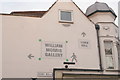 View of direction signs to the William Morris Gallery and Town Hall painted on the side of Salvage Electrical from Ruby Road