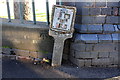 Benchmark and gas pipe marker at north end Main Street