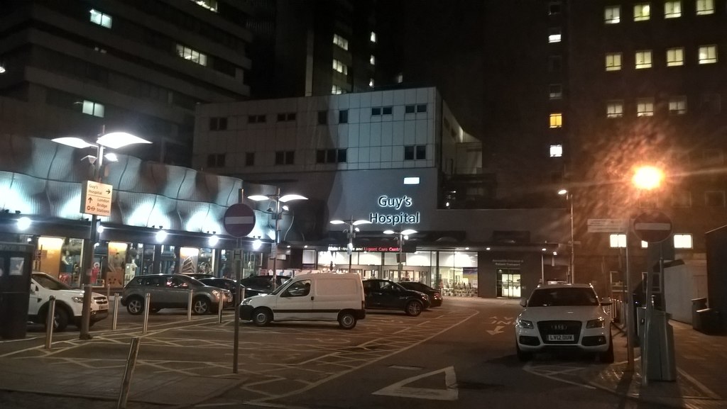 One of the entrances to Guy's Hospital, London at night, with parking cars and bright street lighting © Copyright Paul Bryan and licensed for reuse under Creative Commons Licence https://www.geograph.org.uk/photo/5682030