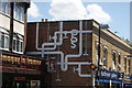 View of plumbing-themed street art on the side of Bathroom Gallery on Wood Street #2