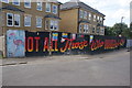 View of street art on construction hoarding in front of newly built houses on West Avenue