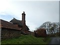 House with high stone and brick chimney, near Stratford Wood