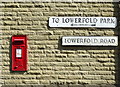 Elizabeth II postbox and old direction sign on Church Street, Great Harwood