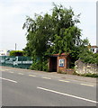 Brick bus shelter under a tree in Shurdington