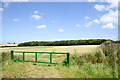 NZ3725 : Wheat field beyond heavy green gate by Trevor Littlewood