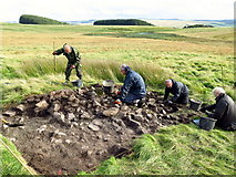 NY8993 : Excavating a stony mound, Fawdon Hill by Andrew Curtis