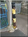 A black/yellow striped pole on Village Road, Llanfairfechan