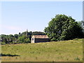 NZ0119 : Barn & spire of Cotherstone Church by Andrew Curtis