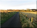 Fence-lined minor road approaching Protston