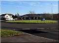 Grassy roundabout opposite three junctions in suburban Carmarthen