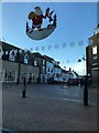 TL5480 : Father Christmas over market Street in Ely by Richard Humphrey