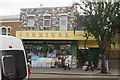 View of the brightly coloured facade of Carnival Cards and Gifts from Leyton High Street