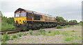 EWS-liveried locomotive hauling empty steel carrier wagons south