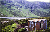 NH6301 : Loch Dubh with corrugated metal building by Trevor Littlewood