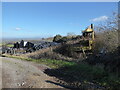 Part of a farmyard with a derelict old JCB hymac long abandoned under briars and brambles