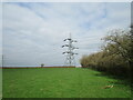 Electricity pylon and footpath along the edge of a grass field