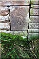 Benchmark on barn at The Luham on SE side of rural road