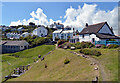 The South West Coast Path passing the playground and village hall, Coverack