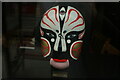 TQ3282 : View of a painted mask in the window of The Old Street Chinese Restaurant #4 by Robert Lamb
