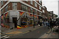 View of street art on a shop front on Brick Lane at the junction with Bacon Street