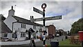 NY4754 : Cumberland County Council signpost and The Queen Inn by Roger Templeman