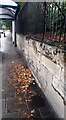 Wall and bus shelter on NW side of Wigton Road opposite Silloth Street