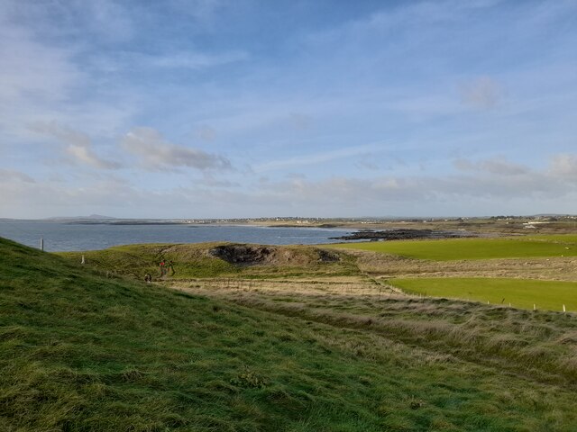 View to Rhosneigr Taken from the Isle of Anglesey Coastal Path north of Cable Bay. Part of the path can be seen in the photograph and Rhosneigr lies distant.