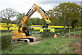 SU6126 : Excavator with pipe lifting gear crossing Joan's Acre Lane by Peter Facey