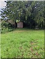 Wooden shed under a churchyard tree, Cwmcarvan