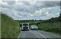 Vehicles passing on the A487, wind turbine on the horizon