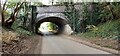 Looking west along Station Road where it passes under bridge of dismantled railway