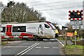 Burston and Shimpling: Railway level crossing with a passing train