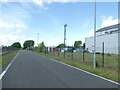 Road and cycle route between fences of Deeside Industrial Estate