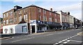 Shops and flats on Curzon Street (A596) at Station Street junction