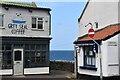 Sea glimpsed between buildings on the corner of Gun Street