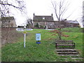 Village pub, sign, waste bin, and bench.