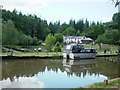 Motor launch on canal with visitor centre in the background