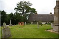 TL2676 : St Peter's churchyard with view to thatched cottage beyond by Fractal Angel